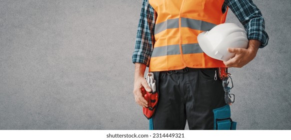 Construction worker wearing personal protective equipment: safety at work concept, banner with copy space