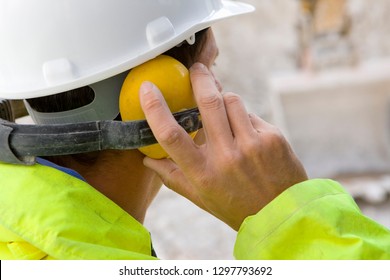 Construction worker wearing protective hard hat and ear defenders - Powered by Shutterstock