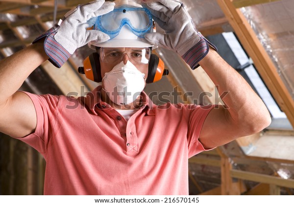 Construction\
worker wearing protective mask in\
attic