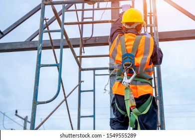 Construction Worker Wearing Safety Harness Belt During Working At High Place.