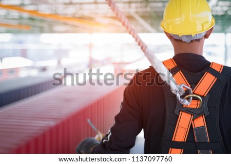 Construction worker wearing safety harness and safety line working at high place