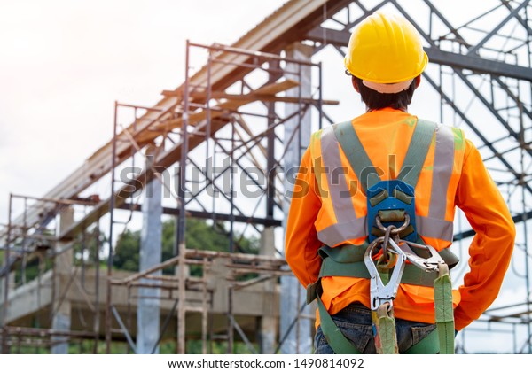 Construction worker wearing safety harness and\
safety line working at high place,Practices of occupational safety\
and health can use hazard controls and interventions to mitigate\
workplace hazards.