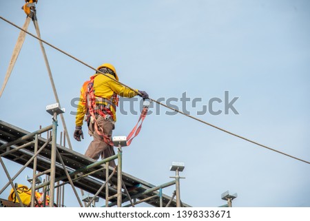 Construction worker wearing safety work at high uniform on scaffolding at construction site