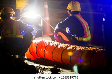 Construction Worker Is Working At Night In Construction Site With Spotlight And Ventilation Pipe For Working In The Underground Tunnel, The Concept Of Hard Work And Over Time.