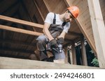 Construction worker working with screwdriver on wooden frame, diy eco-friendly homes concept. Man using drill working on construction of wood modular house