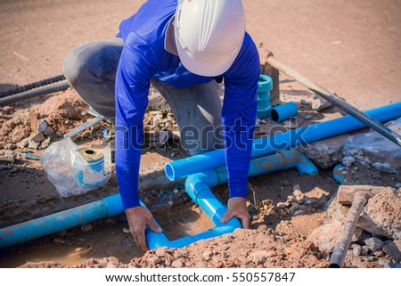 Construction worker,Repairing a broken water pipe on the concrete road.