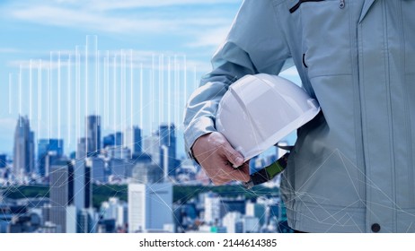 Construction workers against the backdrop of the city - Shutterstock ID 2144614385