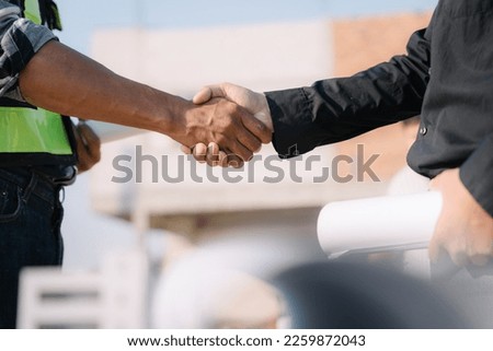 Construction workers, architects and engineers shake hands while working for teamwork and cooperation after completing an agreement in an office facility, successful cooperation concept.