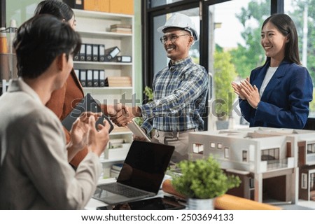 Construction workers, architects and engineers shake hands while working for teamwork and cooperation after completing an agreement in an office facility, successful cooperation concept.