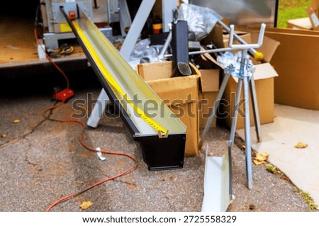 Construction workers assemble gutter channels materials for project in workshop area