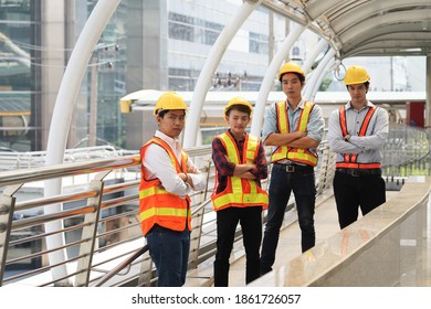 Construction Workers Crew In Hardhats And Safety Vests Standing Together.                              