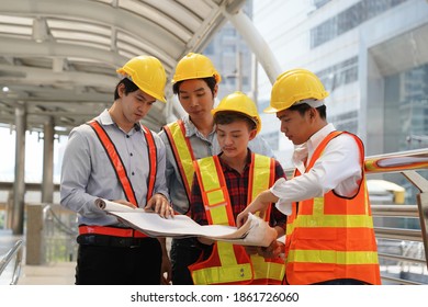 Construction Workers Crew In Hardhats And Safety Vests Standing Together.                              