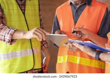 construction workers discussion routine inspection with document and digital tablet,concept of engineering,quality control of construction work - Powered by Shutterstock