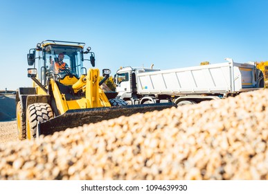 Construction workers doing earthworks with wheel loader and rubble truck