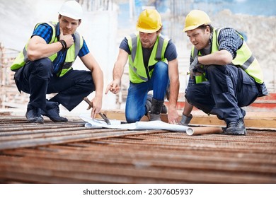 Construction workers engineer reviewing blueprints at construction site - Powered by Shutterstock