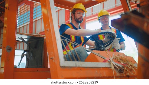 Construction workers engineers in yellow hard hats and safety vests are discussing operate a construction lift machinery within an industrial environment, focus on occupational safety and teamwork - Powered by Shutterstock