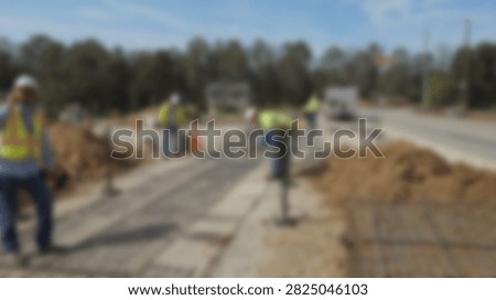 Construction workers in high-visibility safety vests are actively engaged in road repair and infrastructure development, using heavy machinery and tools.