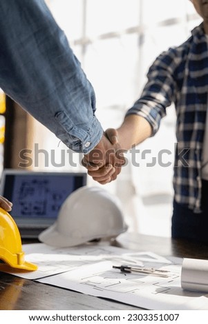 Construction workers holding helmets and vests are shaking hands. real estate concept Architect shaking hands with engineer or builder planning and successful meetings