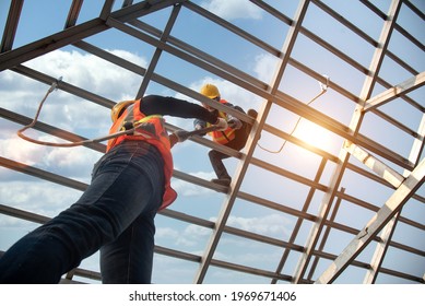 Construction workers install new roofs, roofing tools and fall protection devices. Apply to new roofRoof repair, a Specialist in Roof Forming, is the Replacement of roof plates  - Shutterstock ID 1969671406