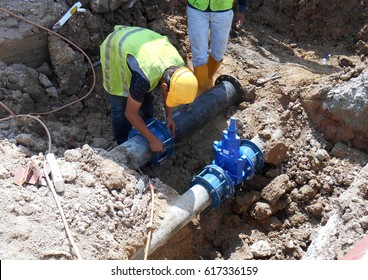 Construction workers install underground utility and services pipe. Trenches was dig to the required level for them to lay the pipes.