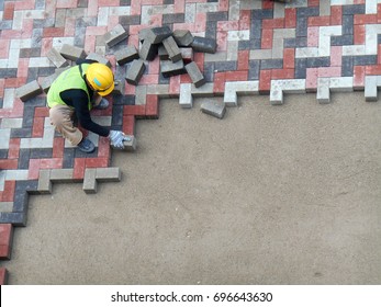 Construction Workers Installing  And Arranging Precast Concrete Pavers Stone For Road At The Construction Site. 