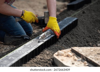 Construction workers installing drainage system channel components at building site