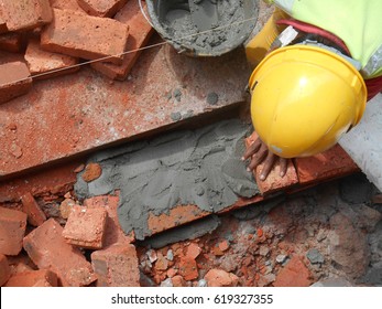 Construction workers laying clay brick to form brick wall at the construction site. The bricks was stick using cement mortars.   