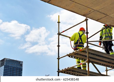 Construction workers on a scaffold. - Shutterstock ID 625438148