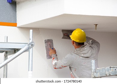 Bauarbeiter vergiften die Fassade des Hauses. Anwendung der Fassade Plaster.