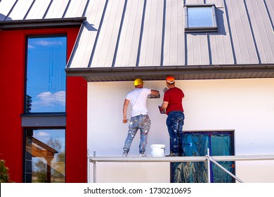 Construction workers plaster the facade of the house. Application Of Facade Plaster.