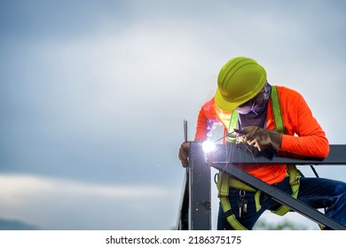 Construction Workers Put On Safety Gear To Work On The Way To Install The Factory Roof Welding Structure.