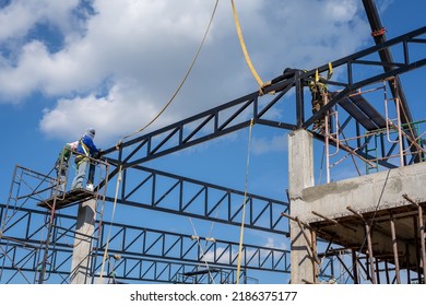 Construction Workers Put On Safety Gear To Work On The Way To Install The Factory Roof Welding Structure.