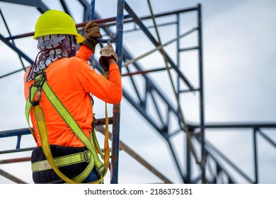 Construction Workers Put On Safety Gear To Work On The Way To Install The Factory Roof Welding Structure.