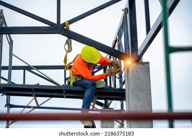 Construction Workers Put On Safety Gear To Work On The Way To Install The Factory Roof Welding Structure.