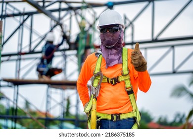 Construction Workers Put On Safety Gear To Work On The Way To Install The Factory Roof Welding Structure.