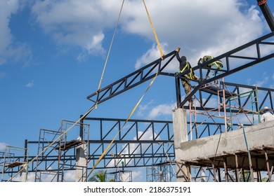 Construction Workers Put On Safety Gear To Work On The Way To Install The Factory Roof Welding Structure.