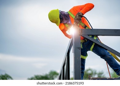 Construction Workers Put On Safety Gear To Work On The Way To Install The Factory Roof Welding Structure.