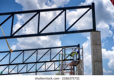 Construction Workers Put On Safety Gear To Work On The Way To Install The Factory Roof Welding Structure.