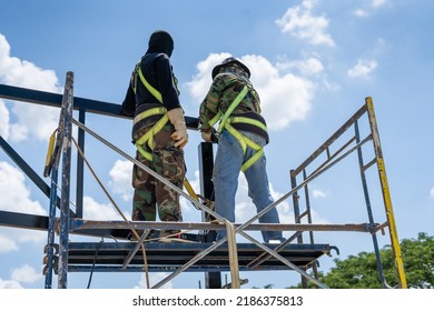 Construction Workers Put On Safety Gear To Work On The Way To Install The Factory Roof Welding Structure.