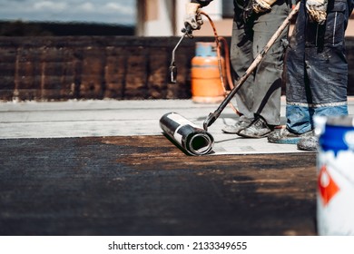 Construction Workers, Roofers Installing Rolls Of Bituminous Waterproofing Membrane