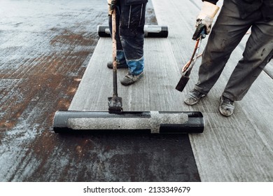 Construction Workers, Roofers Installing Rolls Of Bituminous Waterproofing Membrane