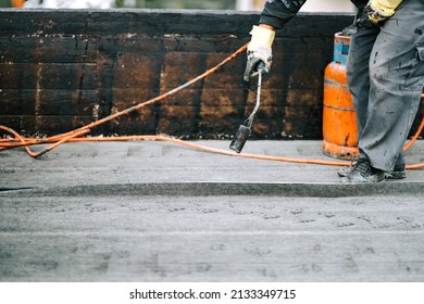 Construction Workers, Roofers Installing Rolls Of Bituminous Waterproofing Membrane
