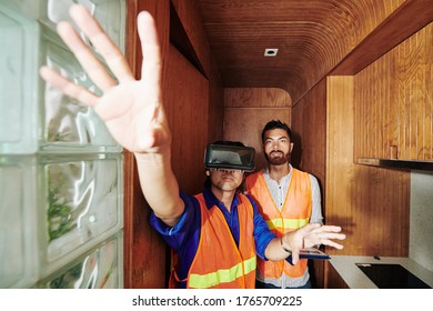 Construction workers testing virtual reality headset in log cabin they built