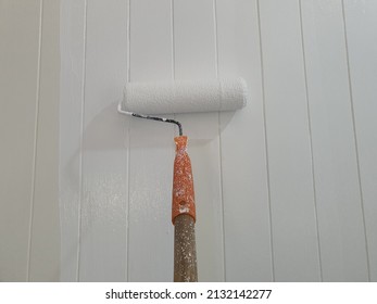 Construction Workers Use Paint Roller To Prime The Left Wall