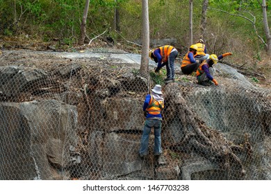 Construction workers are using the mesh to cover the large rocks on the side of the road. In order not to let the stone fall down.