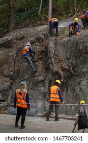 Construction workers are using the mesh to cover the large rocks on the side of the road. In order not to let the stone fall down.