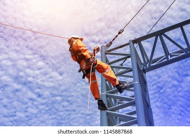 Construction Workers Wearing Safety Harness Belt During Training At High Place, Construction Workers Tying  On Road Construction Structure With On Blue Sky Background
