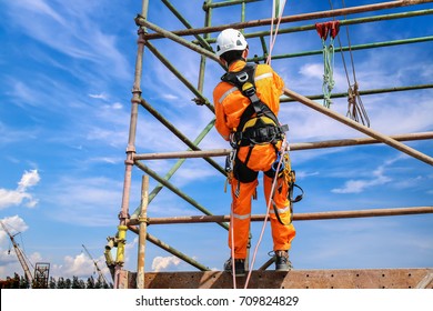 Construction Workers Wearing Safety Harness Belt During Training At High Place