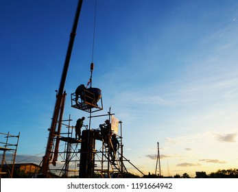 Construction Workers Working On Scaffolding With Blue Sky At Construction Site