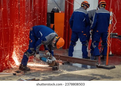 Construction works. Man with circular saw. Worker saws metal. Guy in helmet holds hand-held circular saw. Construction worker uses mask to protect against sparks. Circular saw rental concept - Powered by Shutterstock